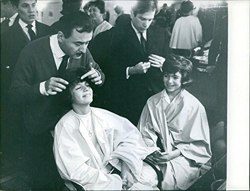 תצלום וינטג 'של מגברים מספרות העושות עבודות שיער על הנסיכה יסמין אגא חאן והגברת מכון יופי .1961.